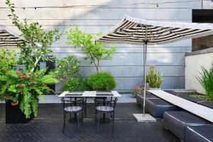 a patio with a table and chairs and plants at Publica Isrotel, Autograph Collection in Herzliya