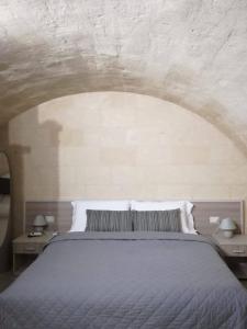 1 dormitorio con 1 cama y 2 mesas con lámparas en B&B La Gemma dei Sassi en Matera