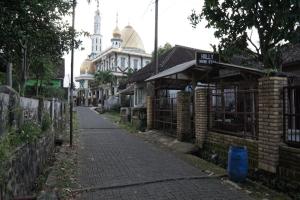 eine leere Straße mit einem Gebäude mit einer Moschee in der Unterkunft SPOT ON 92698 Holy Homestay in Banyuwangi