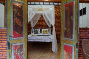 a bedroom with a bed with a canopy at Hotel O Holy HomestayNearWisata Kopi Desa Tamansari in Banyuwangi