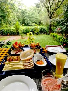 een tafel met een dienblad met eten erop bij The Cattleya Guest House in Sigiriya