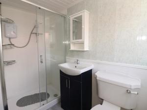 une salle de bain avec toilettes, lavabo et douche dans l'établissement Swiss Cottage, à Bridlington 11 autres photos