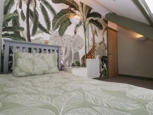a bedroom with a bed and a mural of trees at Pen-Croeslan Bach in Crickhowell