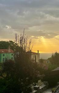 uma vista para uma casa e para o oceano ao pôr-do-sol em Vaela Hotel Cultural Resort em Elatochori