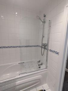 bagno bianco con vasca e doccia di Stylish Modern Apartment, FREE SECURE Parking a Allesley