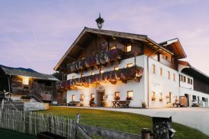 a large white building with flower boxes on it at Obergrundhof in Leogang