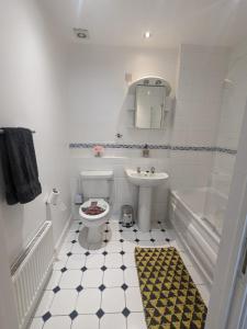 e bagno con servizi igienici, lavandino e vasca. di Stylish Modern Apartment, FREE SECURE Parking a Allesley