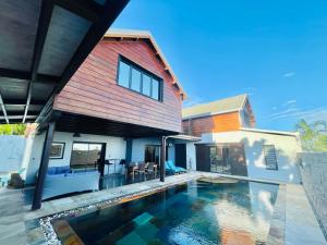 uma casa com piscina em frente a uma casa em Villa Hermès chambre en suite parentale em Saint-Pierre