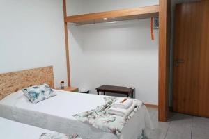 a bedroom with a white bed and a wooden door at Cantinho do Cruzeiro Lajes in Lajes