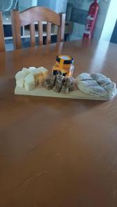 a plate of cheese and bread on a wooden table at Cantinho do Cruzeiro Lajes in Lajes