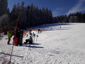 un grupo de personas en una pista de esquí cubierta de nieve en Pension Klose, en Kubova Huť