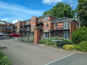 a brick apartment building with a black gate at Stylish Modern Apartment, FREE SECURE Parking in Allesley