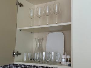 - une étagère avec des verres à vin et un miroir dans l'établissement Dream Apartments at Alliance Palace, à Batoumi