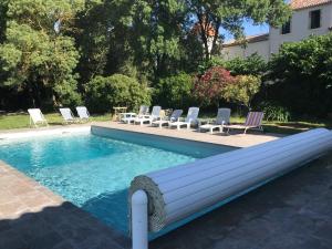 a swimming pool with lounge chairs and a swimming pool at Maison Majorelle in Moussoulens