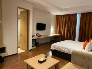 雅加達的住宿－Grand G7 Hotel Pasar baru，配有一张床和一张书桌的酒店客房