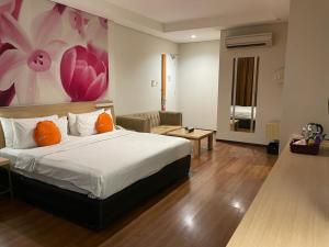 - une chambre avec un lit et une peinture murale dans l'établissement Grand G7 Hotel Pasar baru, à Jakarta