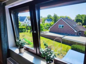 ventana con vistas a una casa en FeWo Suite Spaltsberg am Binnenwasser en Neustadt in Holstein