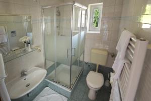 a bathroom with a shower and a toilet and a sink at Hotel Stanger in Lovran