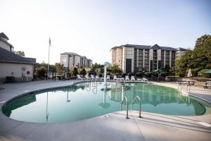 uma grande piscina com cadeiras e edifícios ao fundo em MVC - Unit 2404 - Mountain Mischief em Pigeon Forge