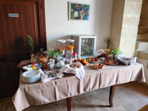 una mesa con comida y platos en masseria Furca, en Serra Alimini