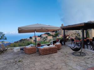 um pátio com guarda-sóis, cadeiras e uma mesa em Giglio Castello - alloggi Mario & Marta em Isola del Giglio