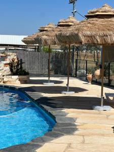 una piscina con sombrillas de aiki y una piscina en Atnachta BaGilboa en Addirim