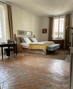 ein Schlafzimmer mit einem Bett und einem Tisch darin in der Unterkunft Le Murier in Vaison-la-Romaine