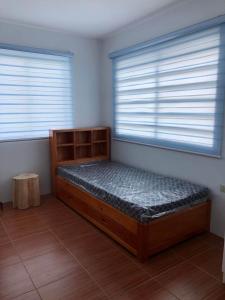 Bett in einem Zimmer mit 2 Fenstern in der Unterkunft MM & Naomi staycation in Mexico
