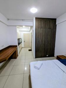 a bedroom with a white bed and a wooden cabinet at PLUTO HOMES in Greater Noida