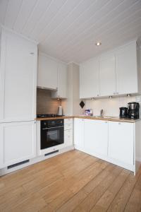 una cucina bianca con armadi bianchi e pavimenti in legno di Havsdalsgrenda Geilo Apartments a Geilo