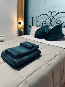 einen Stapel Handtücher auf dem Bett in der Unterkunft La balena bianca house in Bagni San Filippo