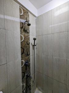 a shower in a bathroom with a stone wall at PLUTO HOMES in Greater Noida