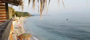 a beach with umbrellas and people on the water at Sempaola Borsh Apartments in Borsh