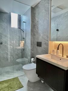 een badkamer met een toilet, een wastafel en een douche bij Central Apartment St Leonards in Sydney