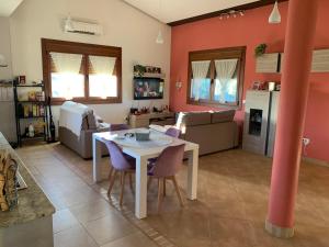 een keuken en een woonkamer met een witte tafel en paarse stoelen bij Acogedora casa de campo,muy cómoda in Ourense
