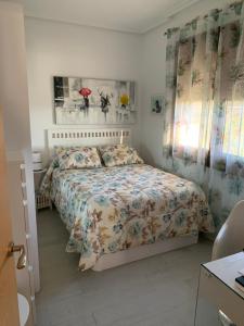 een slaapkamer met een bed met een bloemenbed bij Acogedora casa de campo,muy cómoda in Ourense