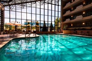 a large swimming pool in a building with a large window at Marriott Melville Long Island in Melville