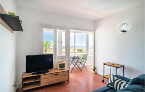 a living room with a television and a table with chairs at Beautiful Apartment In Cabo De Gata With 2 Bedrooms And Outdoor Swimming Pool in El Cabo de Gata