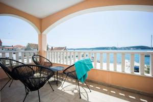 balcón con sillas y mesa con vistas al agua en Sea you Soon by the beach, 2-bedrooms suite in Seget Donji, en Trogir