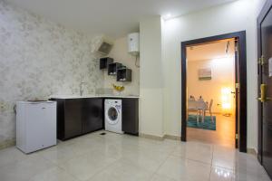 a kitchen with a washer and a washing machine in it at Al Basem Hotel in Amman
