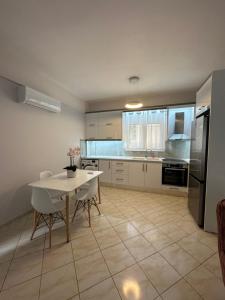 a kitchen with a table and a white table and chairs at Saranda Apartments in Sarandë