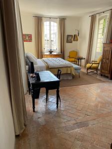 ein Wohnzimmer mit einem Bett und einem Tisch in der Unterkunft Le Murier in Vaison-la-Romaine