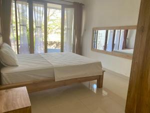 Un dormitorio con una cama y una ventana grande. en Bali Paranes, en Nusa Dua
