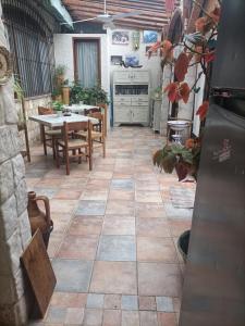 eine Terrasse mit einem Tisch und Stühlen sowie Steinboden in der Unterkunft La Casa In Pietra in Santa Caterina Villarmosa