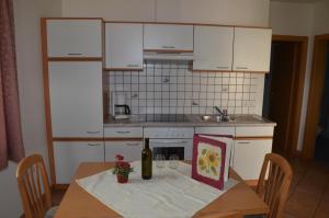 a kitchen with a table with a bottle of wine at Ansitz Weissenheim in Appiano sulla Strada del Vino