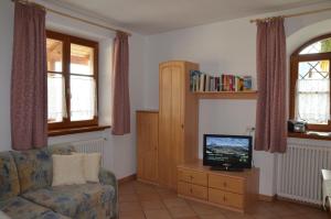 a living room with a couch and a tv at Ansitz Weissenheim in Appiano sulla Strada del Vino +2 photos
