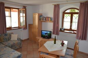 a living room with a couch and a table with a tv at Ansitz Weissenheim in Appiano sulla Strada del Vino