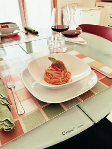 einen Teller Pasta auf einem Tisch in der Unterkunft Sunny House Fourteen in Assemini