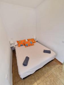 - un lit blanc avec des oreillers orange dans l'établissement Apartamento Albatros Beach-6, à Empuriabrava