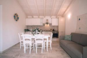 - une cuisine avec une table, des chaises blanches et un canapé dans l'établissement Brand New Villa in La Caletta 500m from the Beach, à La Caletta 18 autres photos
